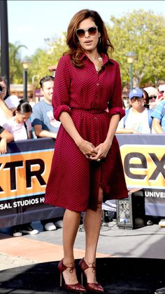 a woman standing in front of a crowd wearing sunglasses