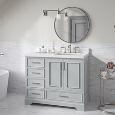 a bathroom with a sink, mirror and bathtub in the middle of the room