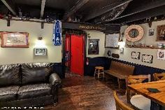 the inside of a restaurant with leather couches, tables and pictures on the wall