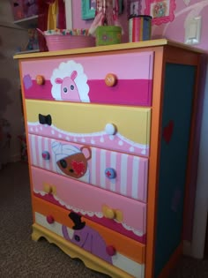 a colorful dresser with an animal theme painted on the top and bottom drawers, in a child's bedroom