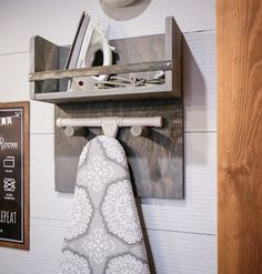 an ironing board mounted to the side of a wall next to a kitchen towel rack