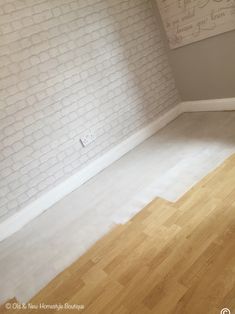 an empty room with white brick walls and hard wood floors