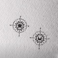 two compasss are drawn on paper with ink