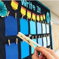 a person holding a pair of scissors in front of a bulletin board