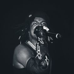 a man with dreadlocks on singing into a microphone