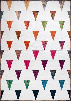 a white quilt with colorful triangles on it