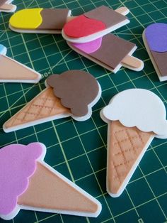 several ice cream cones on a cutting board with some cut outs in the middle to make them look like they have been made out of paper