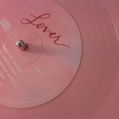 a pink record with the word love written on it's side and a small metal ball at the top