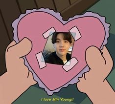 a person holding up a heart shaped object with the words i love min yong on it