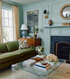 a living room filled with furniture and a fire place in front of a mirror on the wall