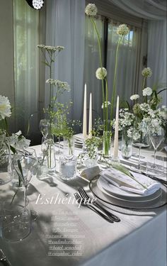 the table is set with white flowers and candles