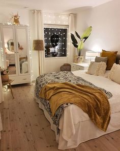 a bedroom with white walls and wooden floors