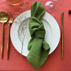 a place setting with green napkins and silverware