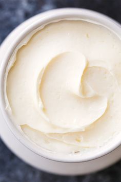 a white bowl filled with cream on top of a table