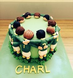 a cake with green frosting decorated with soccer players on it and the word charl spelled out in gold