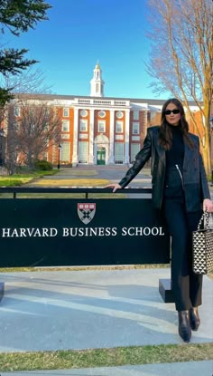 a woman standing next to a sign in front of a building