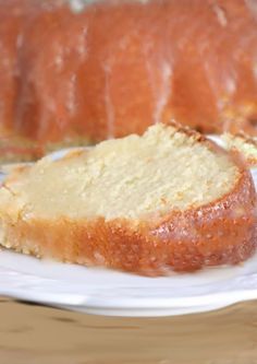 a loaf of lemon pound cake on a white plate next to a slice of lemon pound cake