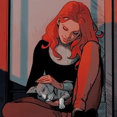 a woman with red hair is holding a cat in her lap and looking down at the ground