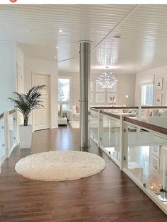 a living room filled with furniture and a white rug on top of a hard wood floor