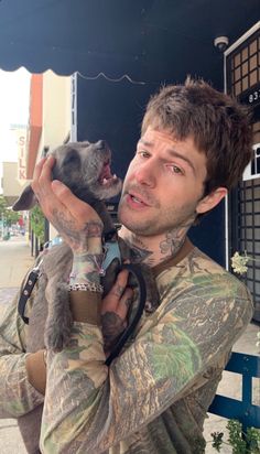 a man holding a small dog in his arms