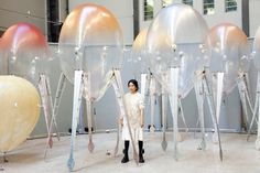 a woman standing in front of an array of balloons