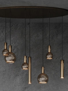 a group of lights hanging from the ceiling in a room with concrete walls and flooring