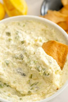 a white bowl filled with dip and chips