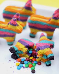 there are some colorful cakes made to look like animals with candy in their mouth and on the ground