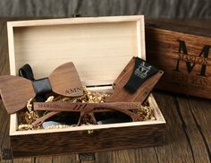 two wooden bow ties in a box on top of a table next to other items