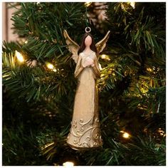 an angel ornament hanging from a christmas tree