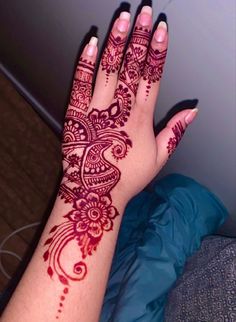 a woman's hand with henna tattoos on it