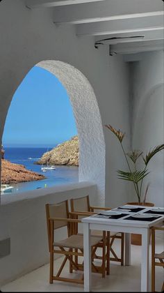 an arched window overlooks the ocean and rocks