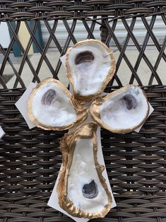 the cross is made out of oysters and wrapped in gold foil on a wicker chair