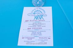 a ticket for an amusement park ride is shown on a blue tablecloth with a drink in it