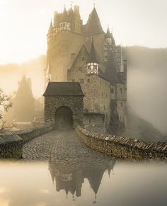 an old castle is shown in the fog