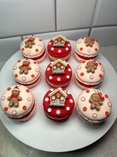 twelve decorated cupcakes on a white plate with red polka dots and ginger bears