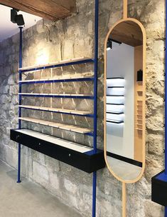 a stone wall with shelves and a mirror