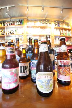 several different types of beer are on the bar top, and there is no image here to provide a caption for