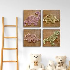 three small crocheted dinosaurs are displayed on the wall