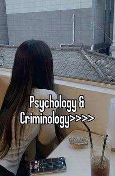 a woman sitting at a table with a cell phone in front of her and the words psychology & criminology ages > > > > > > > > > > > > >