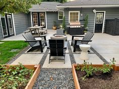 an outdoor patio with chairs, table and grill