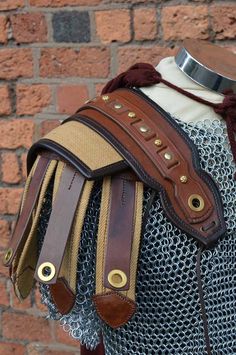 a close up of a mannequin's armor on display in front of a brick wall