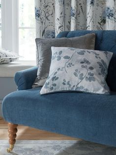 a blue couch sitting in front of a window