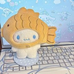 a stuffed fish sitting on top of a laptop computer