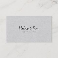 a business card with the words natural spa in black ink on a white marble surface