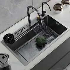 a kitchen sink with a black faucet running water over it's drain