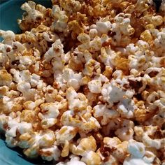 a blue bowl filled with popcorn and marshmallows on top of a table