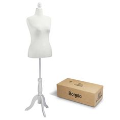 a white mannequin on a stand next to a cardboard box