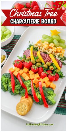 christmas tree charcuterie board with fruit and crackers on the side, including broccoli