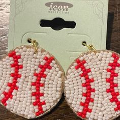 red and white beaded hoop earrings sitting on top of a wooden table next to a card